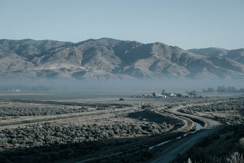 Idaho Treasure Valley or Snake River Plain with mountain backdrop, high desert agricultural character